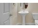 Cozy powder room with pedestal sink, oval mirror, and tiled floors at 2262 Alanhurst Dr, Henderson, NV 89052