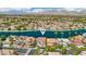 Aerial view showcases a waterfront home in a lush community with mountain views in the background at 2469 Sun Reef Rd, Las Vegas, NV 89128