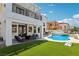 Inviting backyard featuring a pool, lush turf, and an outdoor seating area, ideal for relaxation and entertainment at 2469 Sun Reef Rd, Las Vegas, NV 89128