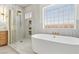 Bathroom features a soaking tub, stand up shower with glass enclosure, and double windows at 2469 Sun Reef Rd, Las Vegas, NV 89128
