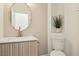 Powder room with decorative mirror, sleek vanity, and a modern toilet at 2469 Sun Reef Rd, Las Vegas, NV 89128