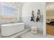 Bright bathroom features a soaking tub with gold fixtures under a window and stylish decor at 2469 Sun Reef Rd, Las Vegas, NV 89128