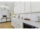 Elegant kitchen featuring white cabinets, marble countertops, and views of the living area at 2469 Sun Reef Rd, Las Vegas, NV 89128