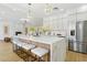Modern kitchen with stainless steel refrigerator, large island with barstool seating, and modern cabinets at 2469 Sun Reef Rd, Las Vegas, NV 89128