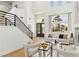 Inviting living room with staircase, large windows, modern furnishings, and neutral color palette at 2469 Sun Reef Rd, Las Vegas, NV 89128
