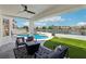 An outdoor living space featuring a fire pit, patio furniture, and pool with views of the lake at 2469 Sun Reef Rd, Las Vegas, NV 89128