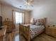 Bedroom with wood flooring, a light wood frame bed, and a ceiling fan at 2473 Luminous Stars St, Henderson, NV 89044
