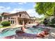 An entertainer's backyard with a custom pool, spa, covered patio, and mature landscaping at 259 Rockwell Springs Ct, Henderson, NV 89012