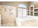 Bathroom featuring a large soaking tub with marble tile and shelving at 259 Rockwell Springs Ct, Henderson, NV 89012