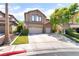 Beautiful two-story home with stone accents, a well-manicured lawn, and three-car garage at 259 Rockwell Springs Ct, Henderson, NV 89012