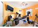 Orange room filled with workout equipment, including a treadmill and recliner at 259 Rockwell Springs Ct, Henderson, NV 89012