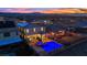 Serene aerial view of a backyard featuring a vibrant pool and jacuzzi with mountain views in the distance at 2714 Frabiele St, Henderson, NV 89044