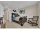 Comfortable bedroom with neutral tones, a queen bed, rocking chair, and natural light at 2714 Frabiele St, Henderson, NV 89044