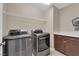 Well-equipped laundry room with modern washer and dryer and a storage shelf and cabinet at 2714 Frabiele St, Henderson, NV 89044