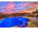 Inviting backyard pool and spa area with custom tile work, perfect for relaxation and outdoor entertaining against a mountain backdrop at 2714 Frabiele St, Henderson, NV 89044