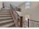 Staircase with carpet steps and wood railing leads to second floor with natural light coming through windows at 2714 Frabiele St, Henderson, NV 89044