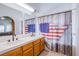 Bathroom with dual sink vanity and shower/tub combo with map shower curtain at 2752 Devita Cir, Las Vegas, NV 89117