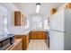 Traditional kitchen with wood cabinets, white countertop, white appliances and tile flooring at 2752 Devita Cir, Las Vegas, NV 89117