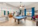 Spacious game room features a pool table, a high ceiling with ceiling fan and large windows with stylish blue curtains at 286 Bowsprit Ct, Las Vegas, NV 89183