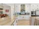 Bright, modern kitchen features custom white cabinetry, stainless appliances, backsplash, and large island with marble countertop at 286 Bowsprit Ct, Las Vegas, NV 89183