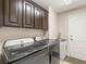 Functional laundry room with modern washer and dryer, sink, and storage cabinets at 286 Bowsprit Ct, Las Vegas, NV 89183