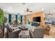 Comfortable living room with leather seating, large windows, and a view of the backyard and opens up to a game room at 286 Bowsprit Ct, Las Vegas, NV 89183