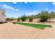 Spacious backyard featuring a unique turf field, desert landscaping, and serene desert surroundings at 3169 Crystal Moon Rd, Henderson, NV 89052
