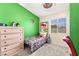 Vibrant bedroom featuring a green accent wall, neutral carpet, and natural light at 3169 Crystal Moon Rd, Henderson, NV 89052