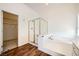 Bright bathroom featuring a soaking tub, glass shower, and doorway to the closet at 324 Quiet Harbor Dr, Henderson, NV 89052