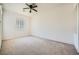 Spacious bedroom features a ceiling fan, neutral carpet and a window with vertical blinds at 324 Quiet Harbor Dr, Henderson, NV 89052