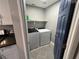 Laundry room with washer, dryer, a shelf, and blue door at 3736 Steinbeck Dr, Las Vegas, NV 89115