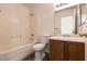A clean, well-lit bathroom with a combined tub and shower, white tile walls, and a vanity with traditional fixtures at 4439 Scarlet Sea Ave, North Las Vegas, NV 89031
