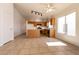 Open-concept kitchen with wood cabinets, stainless steel appliances, and tile flooring seamlessly connecting to the dining area at 4439 Scarlet Sea Ave, North Las Vegas, NV 89031
