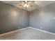 This bedroom features neutral carpeting, soothing gray walls, and a ceiling fan with a light at 5155 Saratoga Dr, Las Vegas, NV 89120