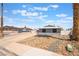 Exterior front view of a gray home with desert landscaping and a long driveway at 5155 Saratoga Dr, Las Vegas, NV 89120