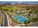 An aerial view of the tennis courts, clubhouse, pools and lush green surroundings, creating a vibrant community at 55 Strada Fontana, Henderson, NV 89011