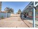 The backyard features a gravel area and brick patio under a covered patio providing shade and extra space at 59 N Christy Ln, Las Vegas, NV 89110