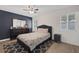 Cozy bedroom features a dark accent wall, patterned bedding, and wood-look floors at 59 N Christy Ln, Las Vegas, NV 89110