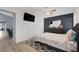 Bedroom featuring wood-look floors, dark accent wall, closet, and gray patterned bedding at 59 N Christy Ln, Las Vegas, NV 89110