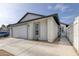 Angle view of house showing two-car garage, walkway and partial fence at 59 N Christy Ln, Las Vegas, NV 89110