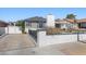 Quaint home showcasing a brick accented fence, lush green shrubs, and mature landscaping at 636 H Ave, Boulder City, NV 89005