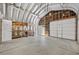 Spacious garage with shelving, work space, and roll up door for easy storage and projects at 636 H Ave, Boulder City, NV 89005