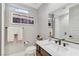 Modern bathroom with a sleek vanity, stylish mirror, and a walk-in shower, bathed in natural light at 659 Spotted Falcon St, Las Vegas, NV 89138