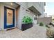 Close-up of townhome entrance with blue door, American flag door decor, and well-maintained courtyard at 659 Spotted Falcon St, Las Vegas, NV 89138
