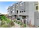 Stylish townhome with modern gray siding, complemented by professionally landscaped greenery and privacy walls at 659 Spotted Falcon St, Las Vegas, NV 89138