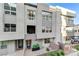 Contemporary townhome featuring a light gray facade, multi-pane windows, and well-kept brick paver courtyard at 659 Spotted Falcon St, Las Vegas, NV 89138