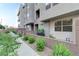 Modern townhome with gray siding, complemented by verdant landscaping along the charming walkway at 659 Spotted Falcon St, Las Vegas, NV 89138