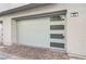 Modern garage door with horizontal windows and brick paver driveway for a contemporary look at 659 Spotted Falcon St, Las Vegas, NV 89138