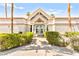A well-maintained clubhouse with an inviting entrance, landscaping, and palm trees under a clear blue sky at 6800 E Lake Mead Blvd # 1018, Las Vegas, NV 89156