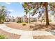 Spacious condo complex with balconies, desert landscaping, mature trees, and paved walkways on a sunny day at 6800 E Lake Mead Blvd # 1018, Las Vegas, NV 89156